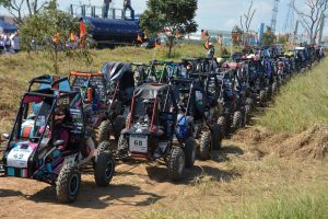 Diversos carros Baja em fila antes da largada da corrida em pista de terra